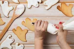 halloween ghost themed sugar cookies being decorated within white and black frosting